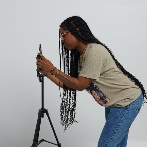 Créatrice préparant un smartphone sur trépied pour les réseaux sociaux