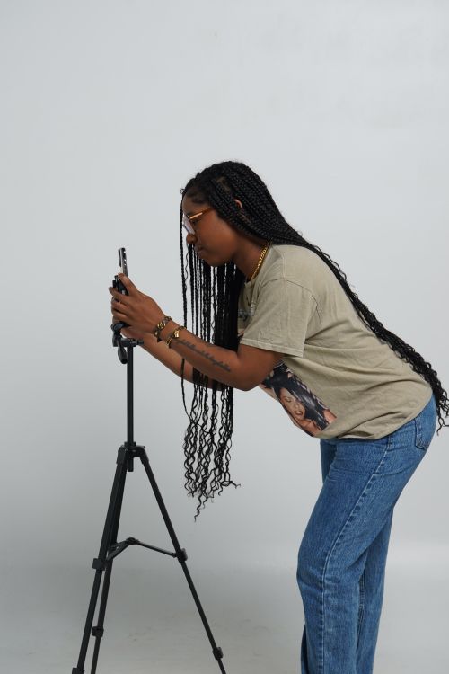 Créatrice préparant un smartphone sur trépied pour les réseaux sociaux