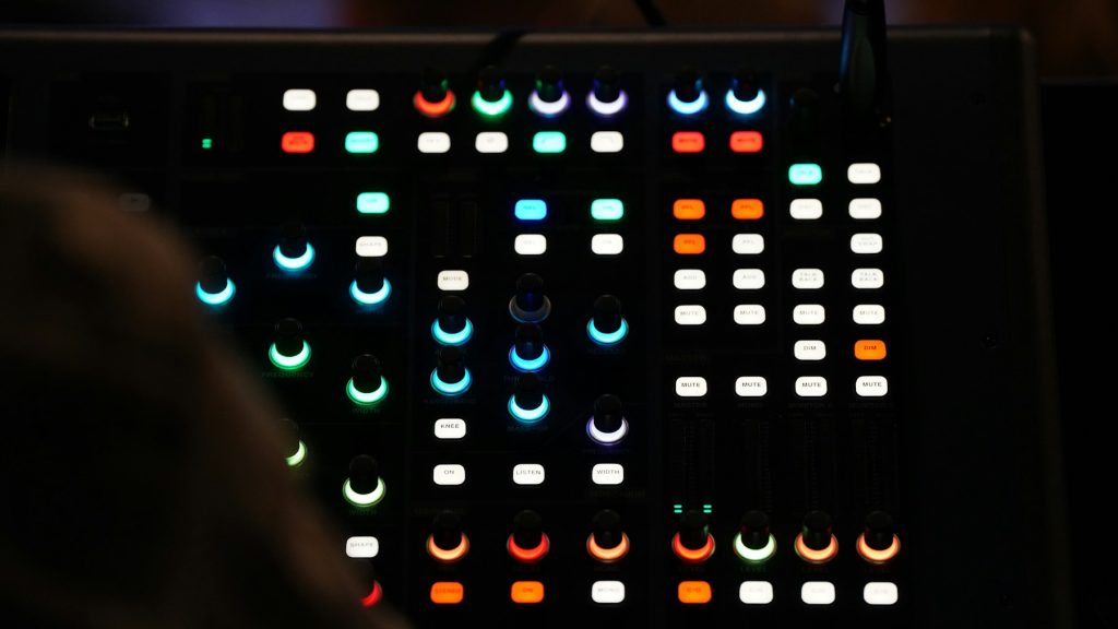 Console audio éclairée dans un studio sombre