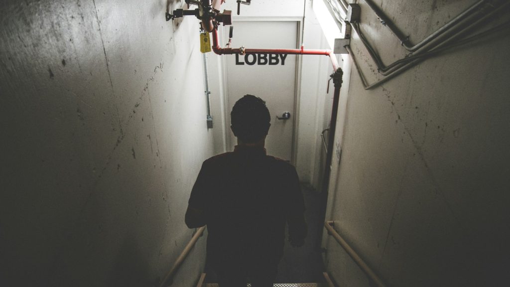 Personne avançant dans un escalier sombre