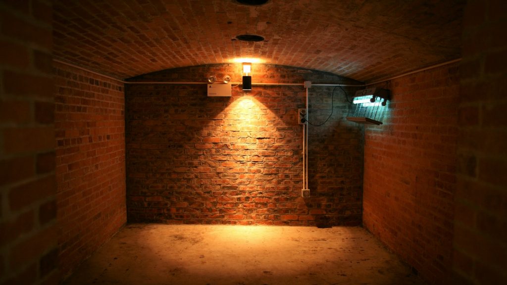Mur sombre éclairé par une ampoule