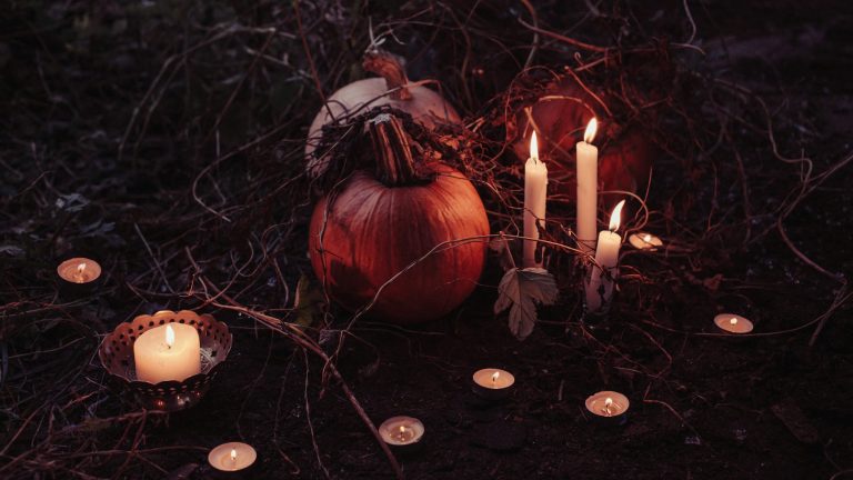 Citrouille entourée de bougies dans une ambiance Halloween